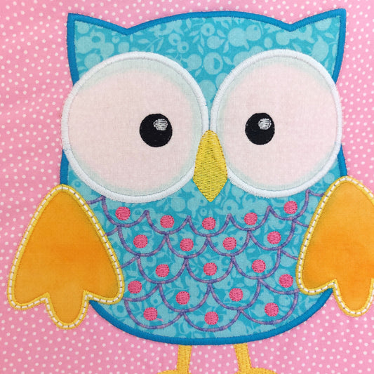 Colourful blue owl design on a pink polka dot background
