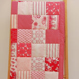 the front of a patchwork quilt made up of different shades of raspberry and cream