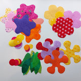 the cut out brightly coloured flowers and leaves ready to be added to the flowers quilt