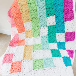 rainbow baby blanket on a chair showing the different coloured flower squares