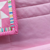 Close-up of pink fabric with colorful border