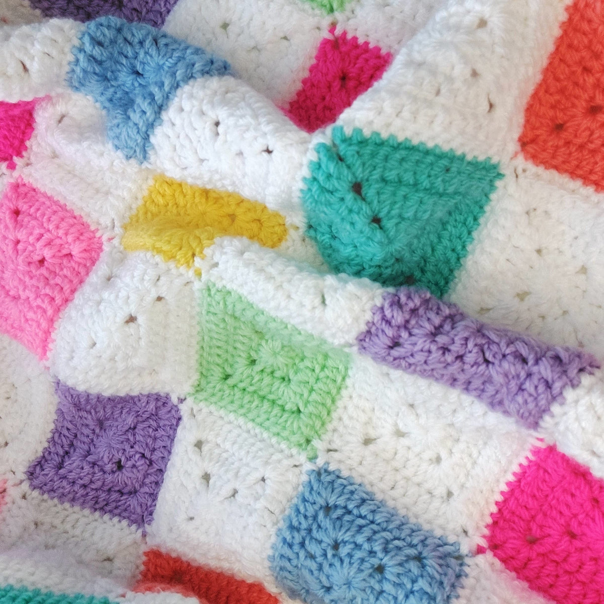 Colorful crocheted blanket with diamond pattern