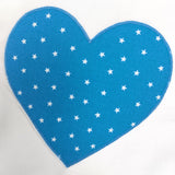 a blue fabric heart with tiny white stars on it sewn on to a white fabric background
