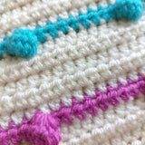 a close up of the purple and blue crochet rainbow bobbles one the handmade crochet rainbow bobble blanket