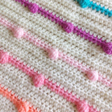 crochet rainbow bobbles on a cream background