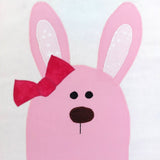 Pink bunny face with a red bow on a white background