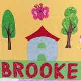 Child's name with a house, trees, and a butterfly on a yellow background