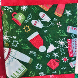 Christmas-themed fabric with mittens, scarves, and trees on a green background
