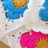 Close-up of a colorful crocheted blanket with hexagonal patterns.