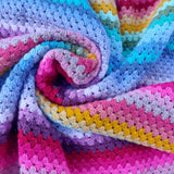 Colorful crocheted blanket with a gradient of pink, purple, blue, and yellow.