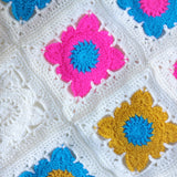 pink and blue and yellow and blue crochet squares joined together with cream