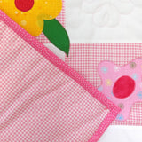 the pink check background of the flowers quilt which is folded over the front