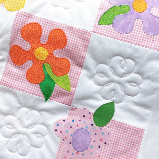 pink check fabric squares with white squares have a bright orange and yellow flower