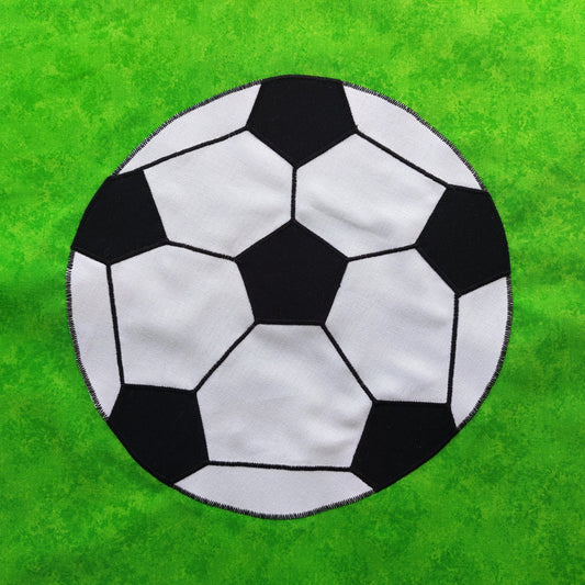 a black and white football on a green background