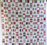 Quilt with Christmas tree pattern in various colors on a white background