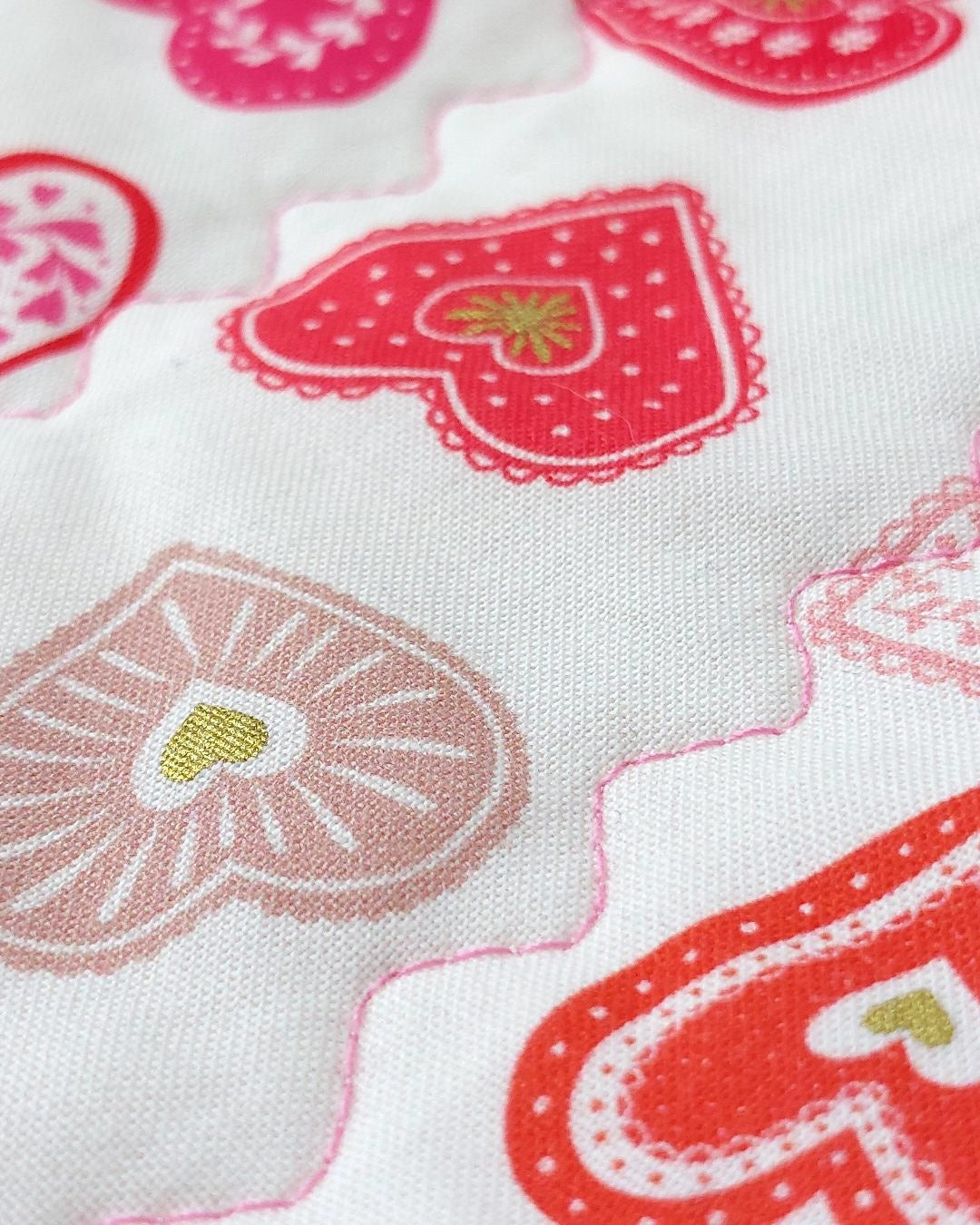fabric showing small hearts in different colours of red, pink and gold