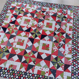 Colorful quilt with geometric pattern on a checkered floor