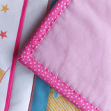 Close-up of pink binding fabric with white polka dots on a colourful background