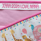 Pink baby blanket with colourful animal patterns and embroidered name text.