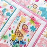 Children's quilt with jungle animal patterns and colourful fabric clips on a white background