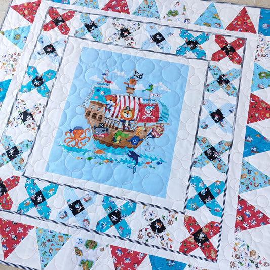Children's quilt with pirate ship design on a white background