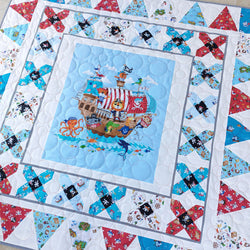 Children's quilt with pirate ship design on a white background