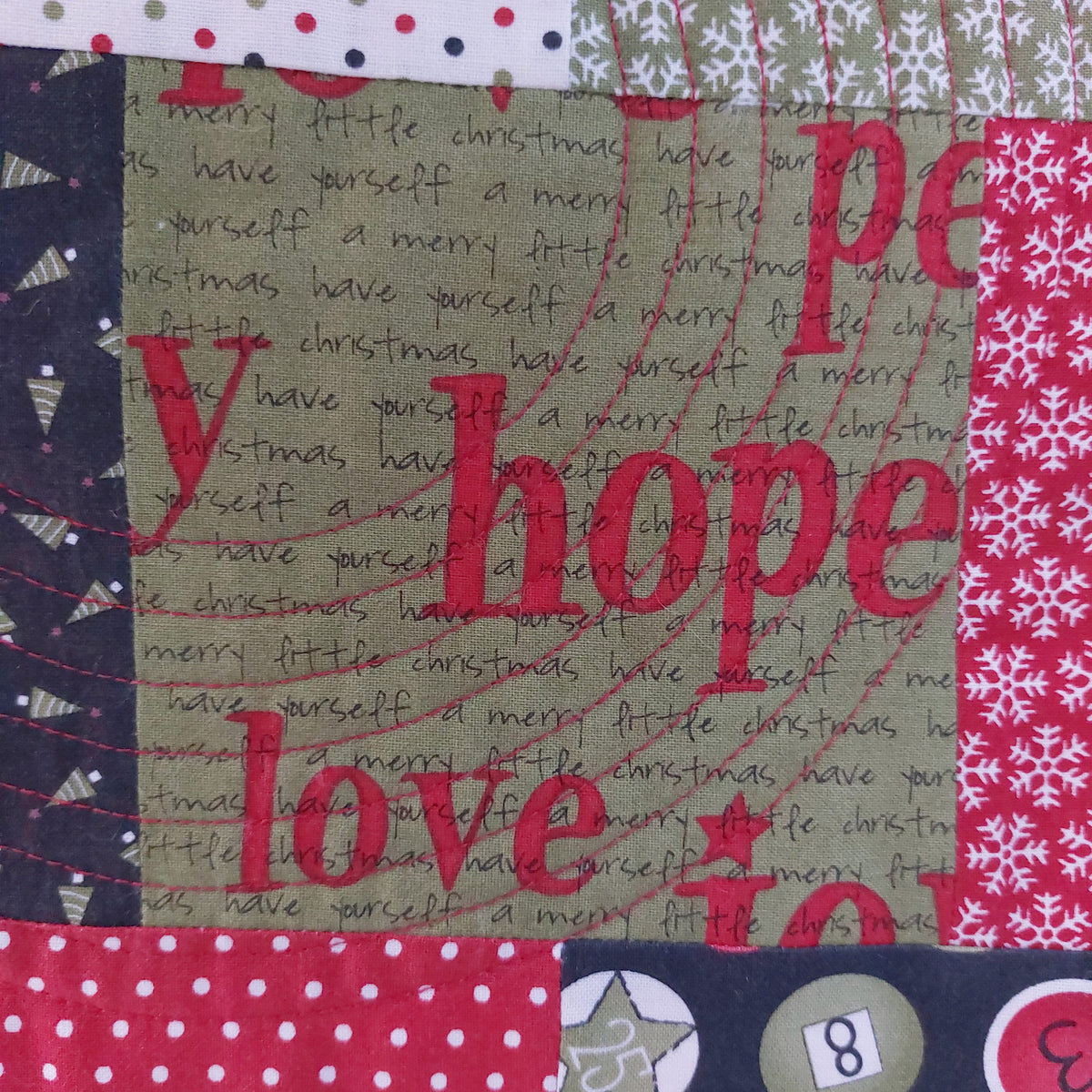 Textured fabric with 'hope love peace' and Christmas patterns