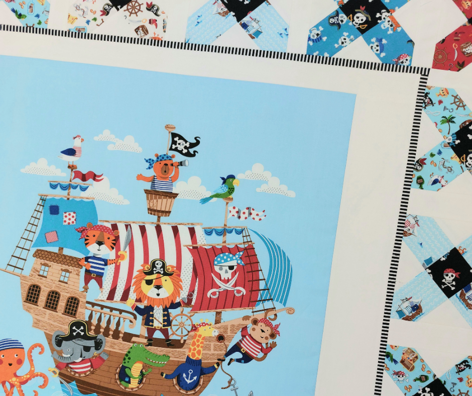 Children's pirate-themed fabric with cartoon characters on a blue background