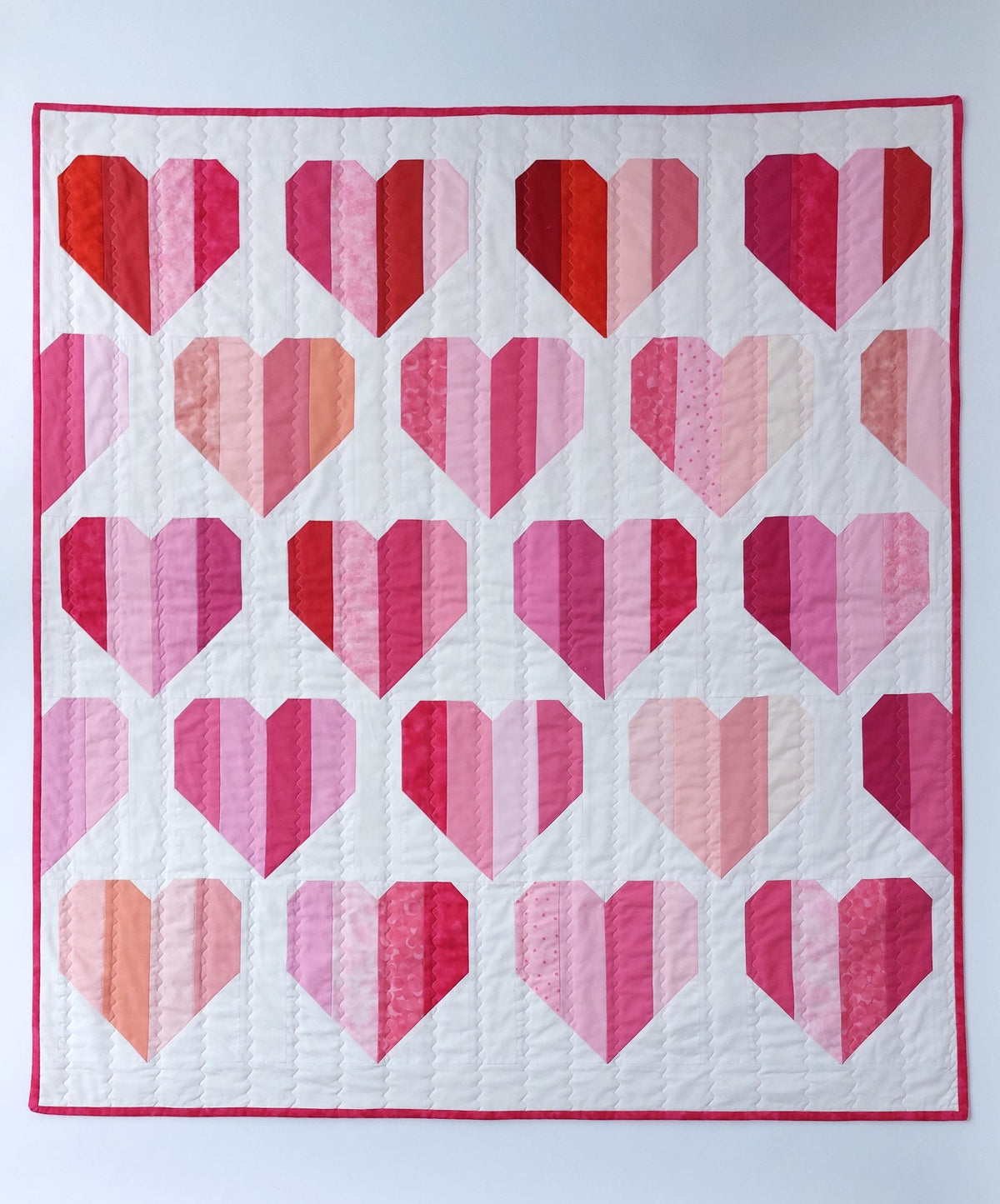 Rows of hearts made of of different coloured strips of red and pink fabric