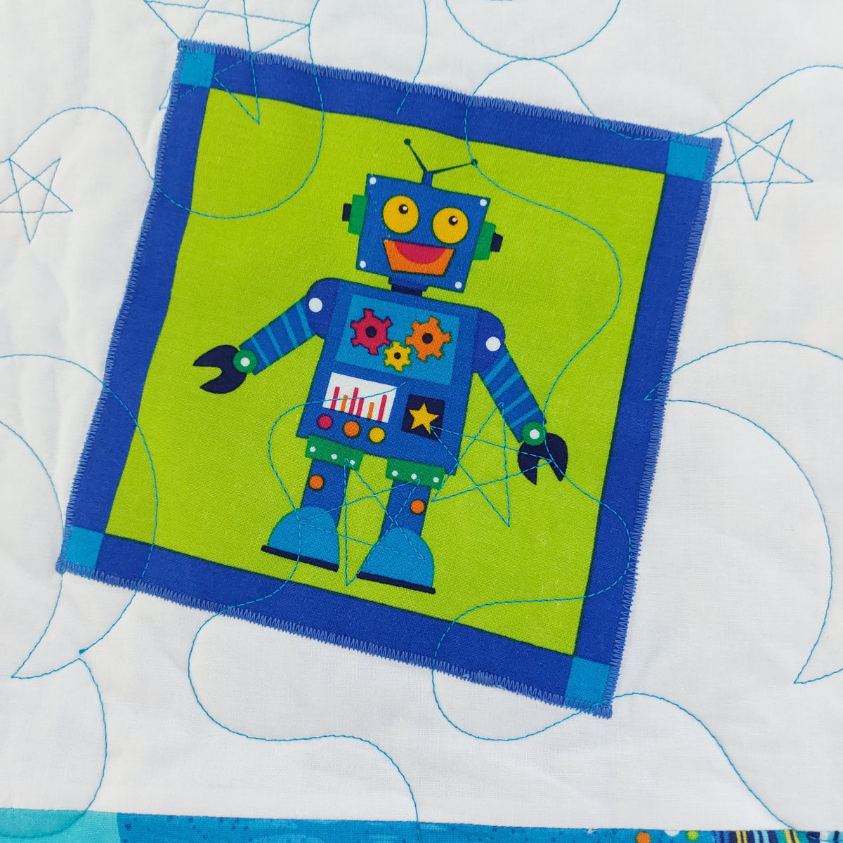 a white square showing  blue robot with a smiling face and showing the moon and stars quilting