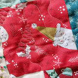 Close-up of a quilt with festive design featuring Christmas trees and snowflakes.