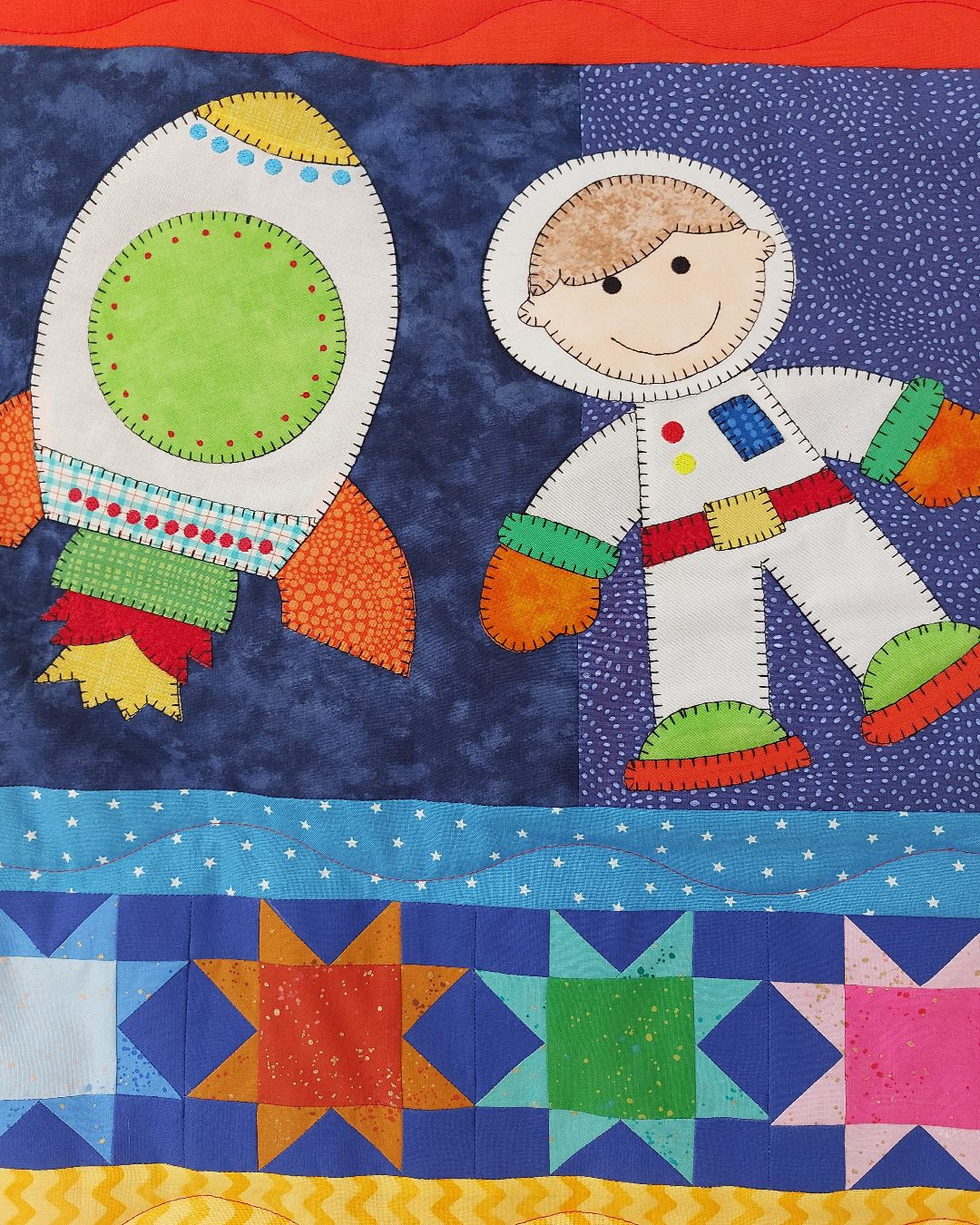 a rocket blasting into space next to a floating boy astronaut wearing a white space suit with brightly coloured patchwork stars underneath