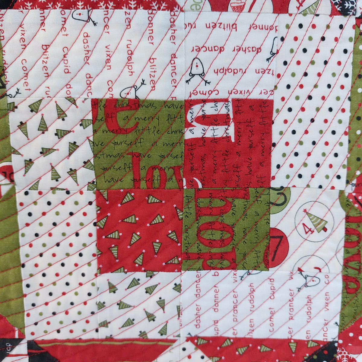 Christmas-themed fabric patchwork with red, green, and white patterns.