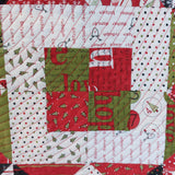 Christmas-themed fabric patchwork with red, green, and white patterns.