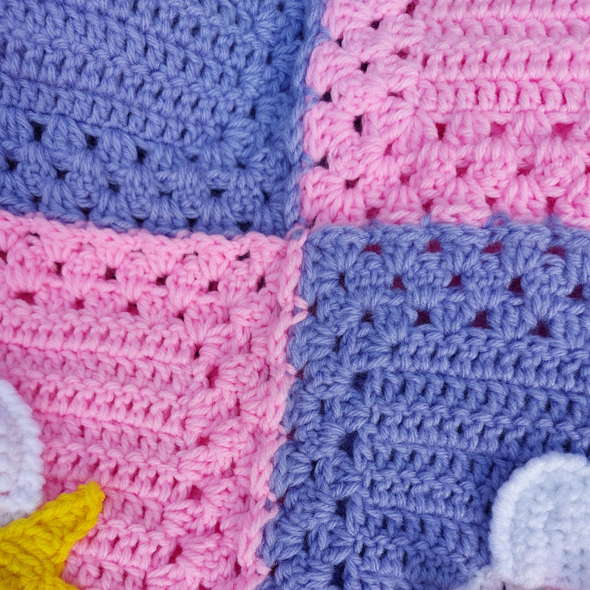 a close up of the purple and pink sections of the handmade unicorn blanket joined together