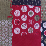 Red fabric with circular patterns and numbers on a patchwork background