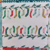 Pattern of colorful socks hanging on a branch with green leaves on a white background.