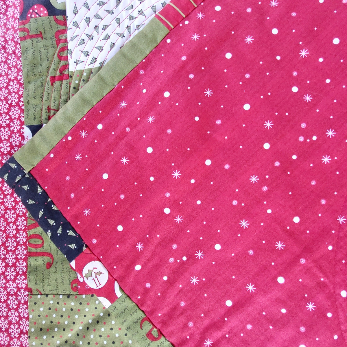 the back of the countdown patchwork quilt which is a red fabric with white dots and stars on it