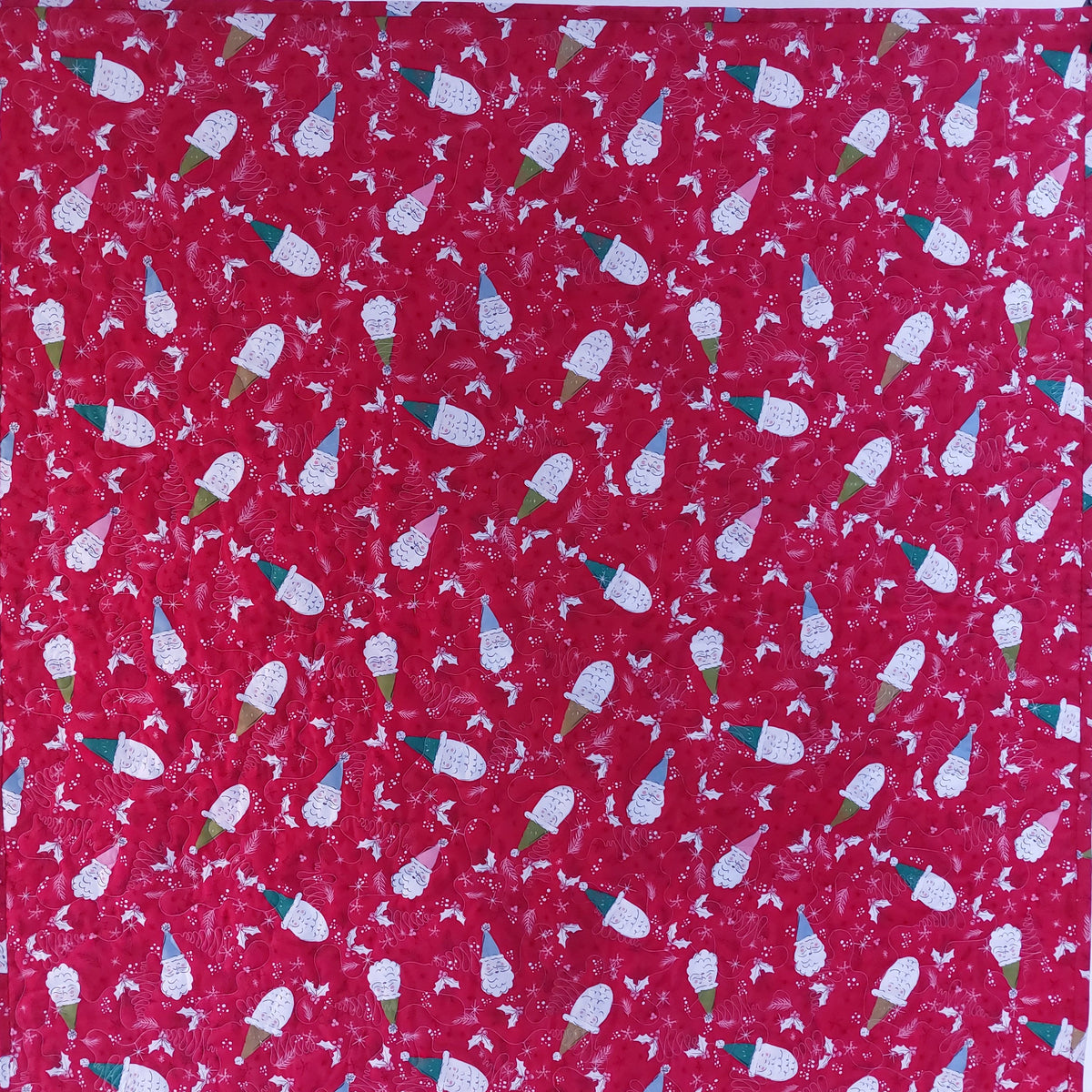 A close-up of a red fabric with a repeating pattern of white and blue ice cream cones and small white floral motifs.