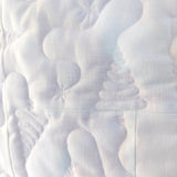 Close-up of a textured white quilted trees fabric surface