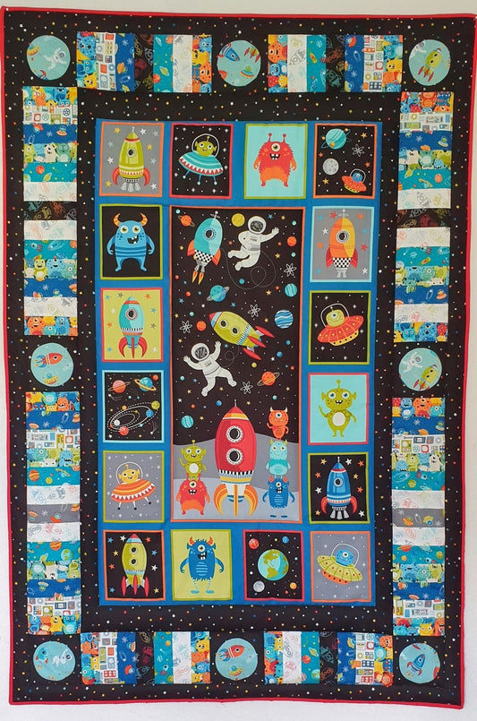 a colourful printed cotton panel showing rockets, fun aliens and spacecraft