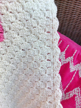 close up photo showing the texture of the cream handmade pink heart baby blanket and also the edging which is in cream too.