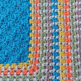 close up of the cute puppy baby blanket border showing the rounds of stitches in yellow, orange, green, blue and brown