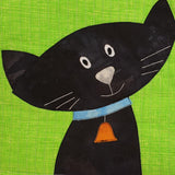bright green background quilt fabric with a black cat sewn on with blue collar and gold bell