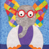 a blue background with a grey elephant who has an purple body, orange toes , red glasses and ears that are made from 1 inch square fabric pieces