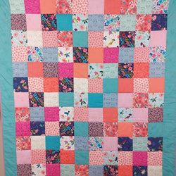 a traditional patchwork quilt made up of rows of squares of fabric all sewn together with a blue border