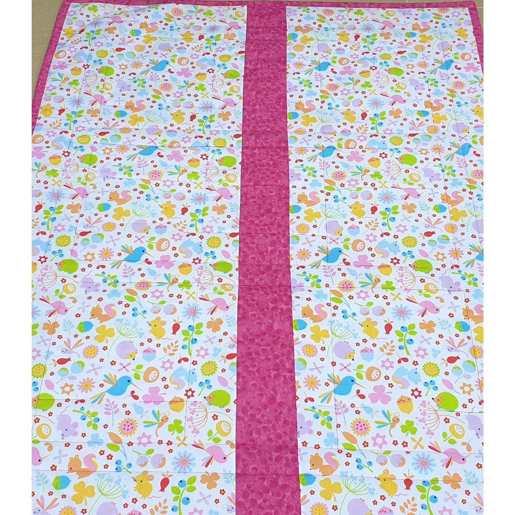 The back view of the jungle quilt made of fabric covered in flowers, birds and rabbits.