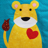 gold lion cub with a brown spotted tail and a big red love heart on its chest