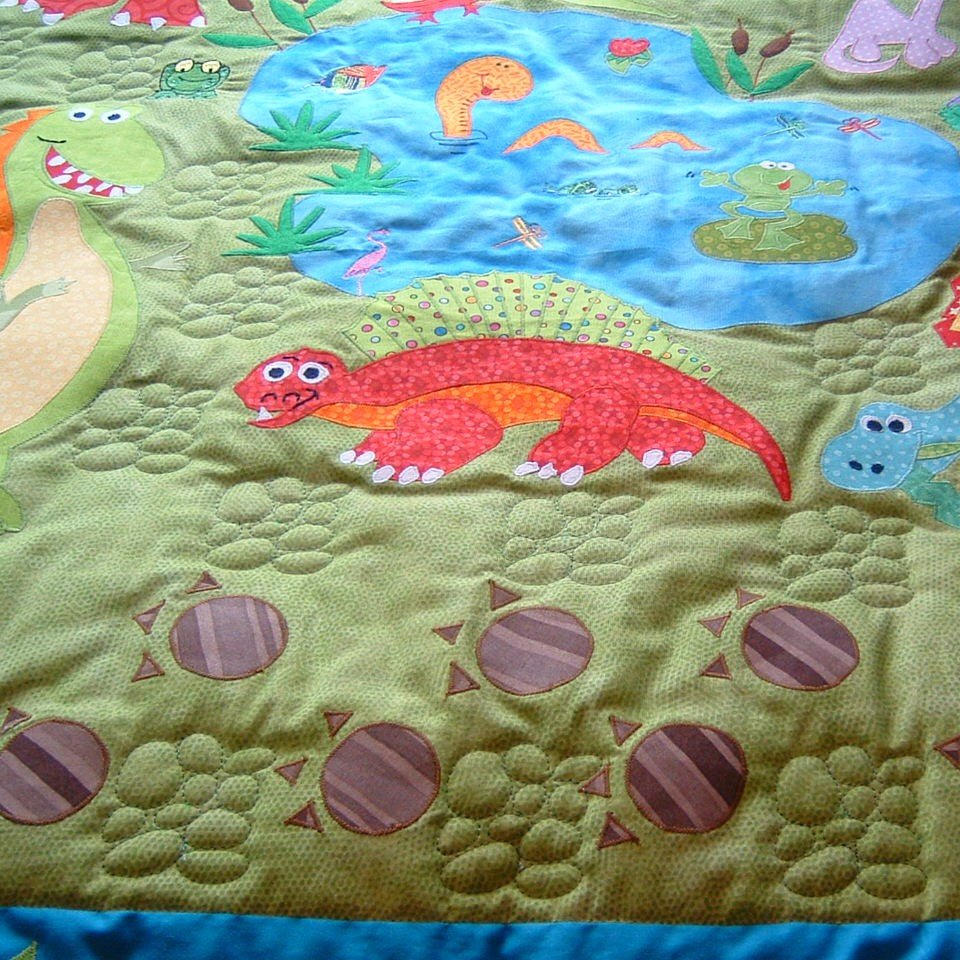 the front of the quilt showing dinosaurs and a pond with lilies and frogs