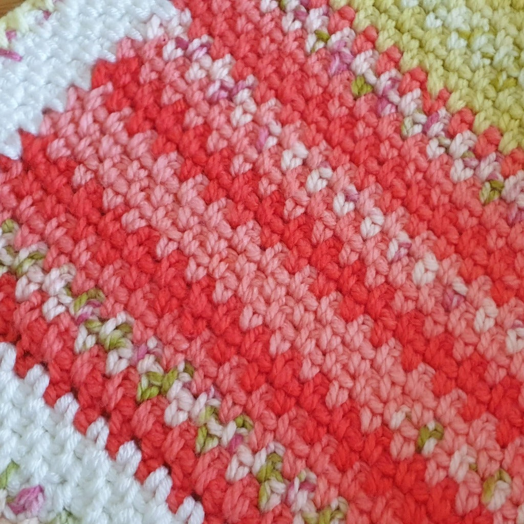 baby blanket stitches shown which change from white rows to a pink and red colour and then to green